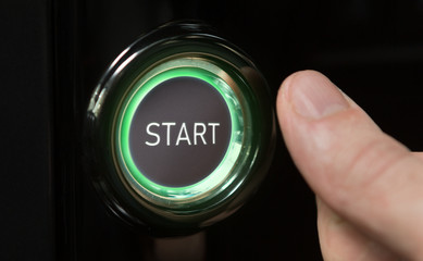 Man pushing green lighted button with word Start
