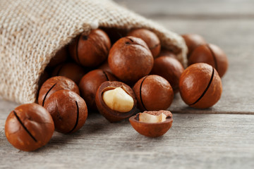 Macadamia nut on a wooden table in a bag, closeup, top view