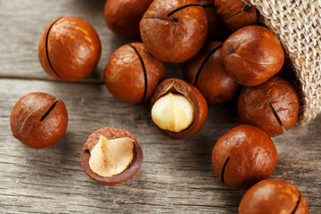 Macadamia nut on a wooden table in a bag, closeup, top view