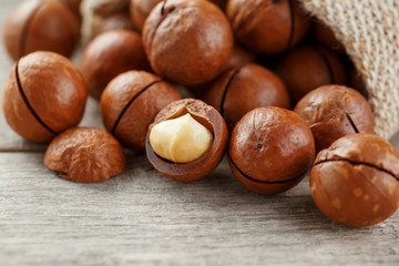 Macadamia nut on a wooden table in a bag, closeup, top view