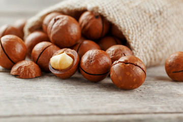 Macadamia nut on a wooden table in a bag, closeup, top view
