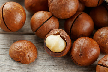 Macadamia nut on a wooden table in a bag, closeup, top view