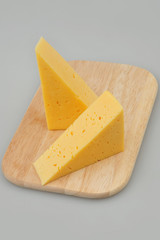 Cheese slice isolated on gray background cutout on a plate