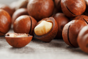 Macadamia nut on a wooden table in a bag, closeup, top view