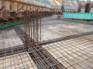 Floor slab and beam reinforcement bar under fabrication at the construction site by workers. It is tied it together using tiny wires. 