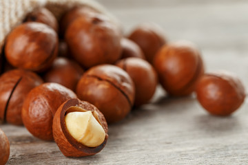 Macadamia nut on a wooden table in a bag, closeup, top view