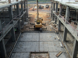 Floor slab and beam reinforcement bar under fabrication at the construction site by workers. It is tied it together using tiny wires. 