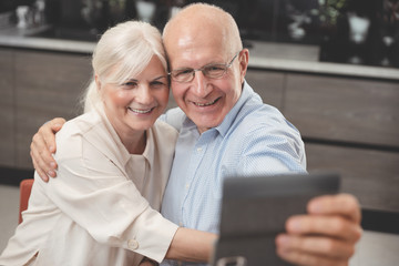 Obraz premium Cheerful senior couple taking selfie