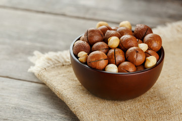 Macadamia nut on wooden background with vintage cloth, concept of superfoods and healthy food