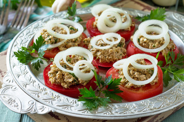 Georgian cuisine close-up. Fresh homemade tomatoes and walnut coriander sauce on the kitchen wooden table.