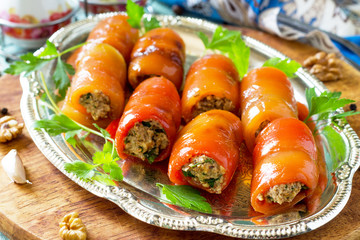 Georgian cuisine close-up. Fresh homemade Rolls of peppers stuffed with nuts on the kitchen wooden table.