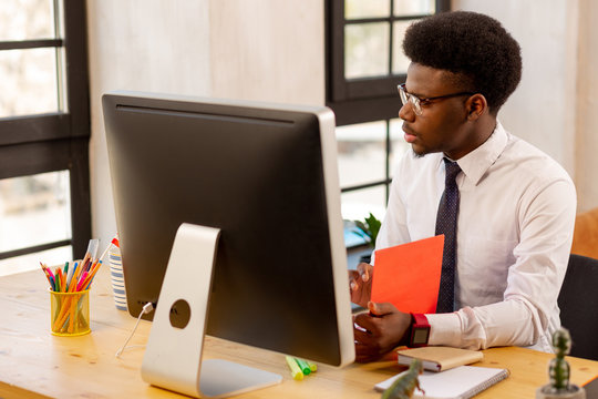 Handsome serious young businessman checking his documentation