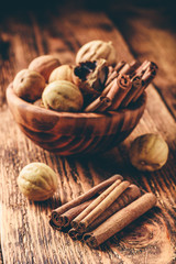 Cinnamon sticks and dried limes in wooden bowl