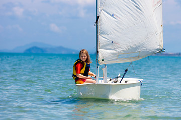 Child sailing. Kid learning to sail on sea yacht.
