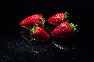 Fresh strawberries isolated on black background with reflections