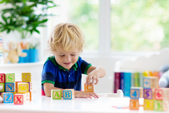 Child Learning Letters. Kid With Wooden Abc Blocks