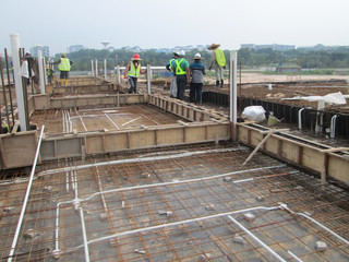 Naklejka premium Floor slab and beam reinforcement bar under fabrication at the construction site by workers. It is tied it together using tiny wires. 