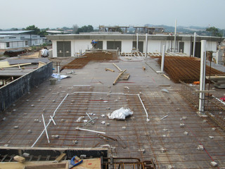 Floor slab and beam reinforcement bar under fabrication at the construction site by workers. It is tied it together using tiny wires. 