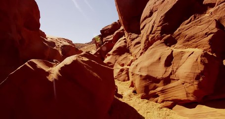 Traveling shot inside a natural geological formation showing orange walls and rocks in 4K