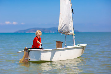 Child sailing. Kid learning to sail on sea yacht.