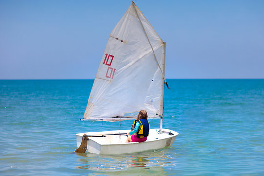 Child sailing. Kid learning to sail on sea yacht.