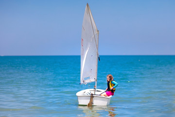 Child sailing. Kid learning to sail on sea yacht.
