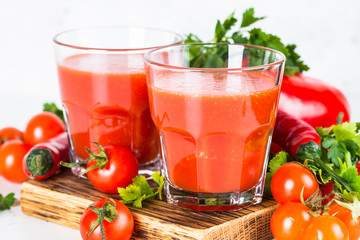 Tomato vegetable juice in glass on white.