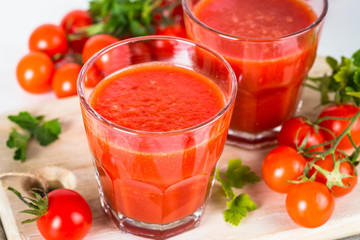 Tomato vegetable juice in glass on white.
