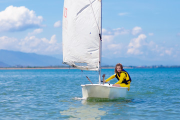 Child sailing. Kid learning to sail on sea yacht.