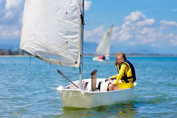 Child sailing. Kid learning to sail on sea yacht.