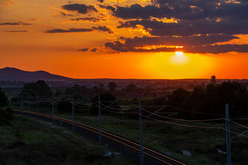 Beautiful summer sunset over empty sunlit railway tracks near Krum, Southern Bulgaria, elevated view from a bridge