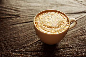 Cup of cappuccino on wooden background