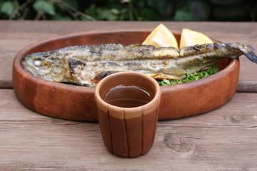 white Georgian wine. white wine in a clay cup against the background of traditional Georgian food