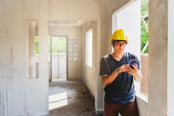 Engineer or Architect using cell phone in building construction site.