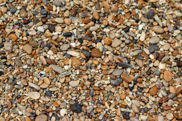 Stone gravel, beach area stone gravel several colors and coral fragments at have shape rounded round caused because of sea waves make give objects bump together all the time cause beauty naturally.
