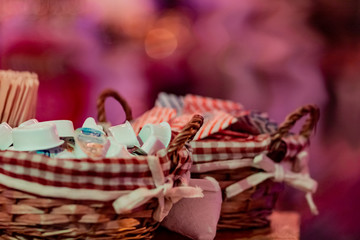 Small milk, coffee creamer pots in basket on red blur background. Mono portions, for catering