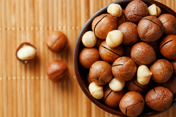 Macadamia nut on bamboo texture, concept of superfoods and healthy food