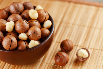 Macadamia nut on bamboo texture, concept of superfoods and healthy food