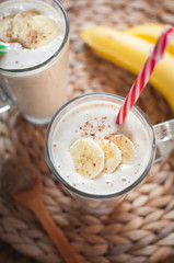 Close-up of banana and flax seeds smoothie in a glass on wooden background