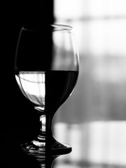 Chessboard effect on a wineglass filled with water.