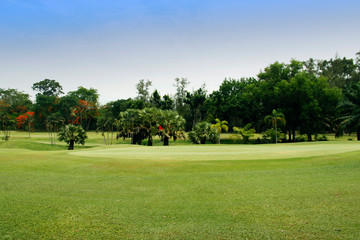 The evening golf course has sunlight shining down at golf course in Thailand