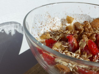 Healthy breakfast of yogurt, strawberries, almonds, nuts, honey and oatmeal.