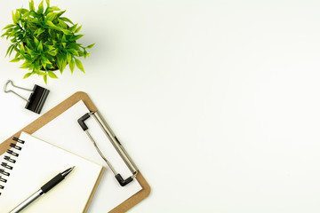white office desk table with a pen on blank notebook. - top view with copy space.