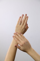 female hands with manicure and rings on white background