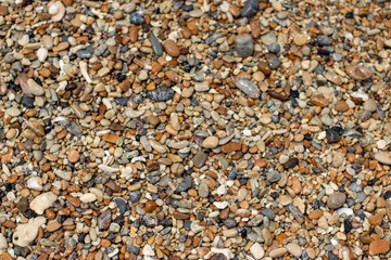 Stone gravel, beach area stone gravel several colors and coral fragments at have shape rounded round caused because of sea waves make give objects bump together all the time cause beauty naturally.