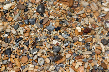 Stone gravel, beach area stone gravel several colors and coral fragments at have shape rounded round caused because of sea waves make give objects bump together all the time cause beauty naturally.