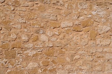 Stone Wall background from very old building construction facade.
