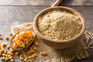 Corn flour in bowl on wooden table