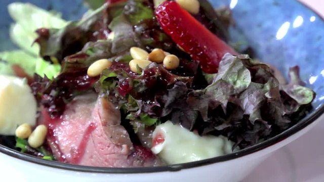 Salad from vegetables and fruit strawberries close-up