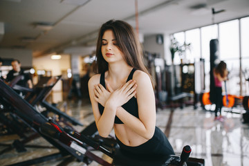 Beautiful girl in the gym. A woman performs exercises. Girl on the simulator
